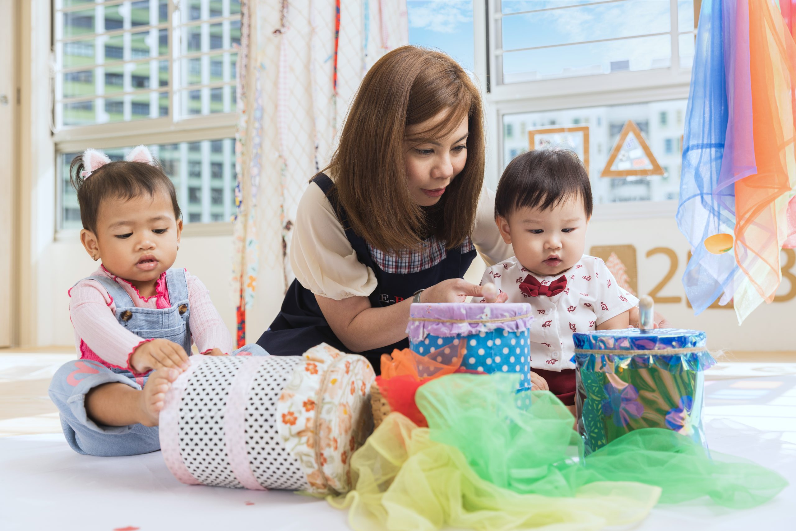 E-Bridge teacher supervising two children in a playgroup