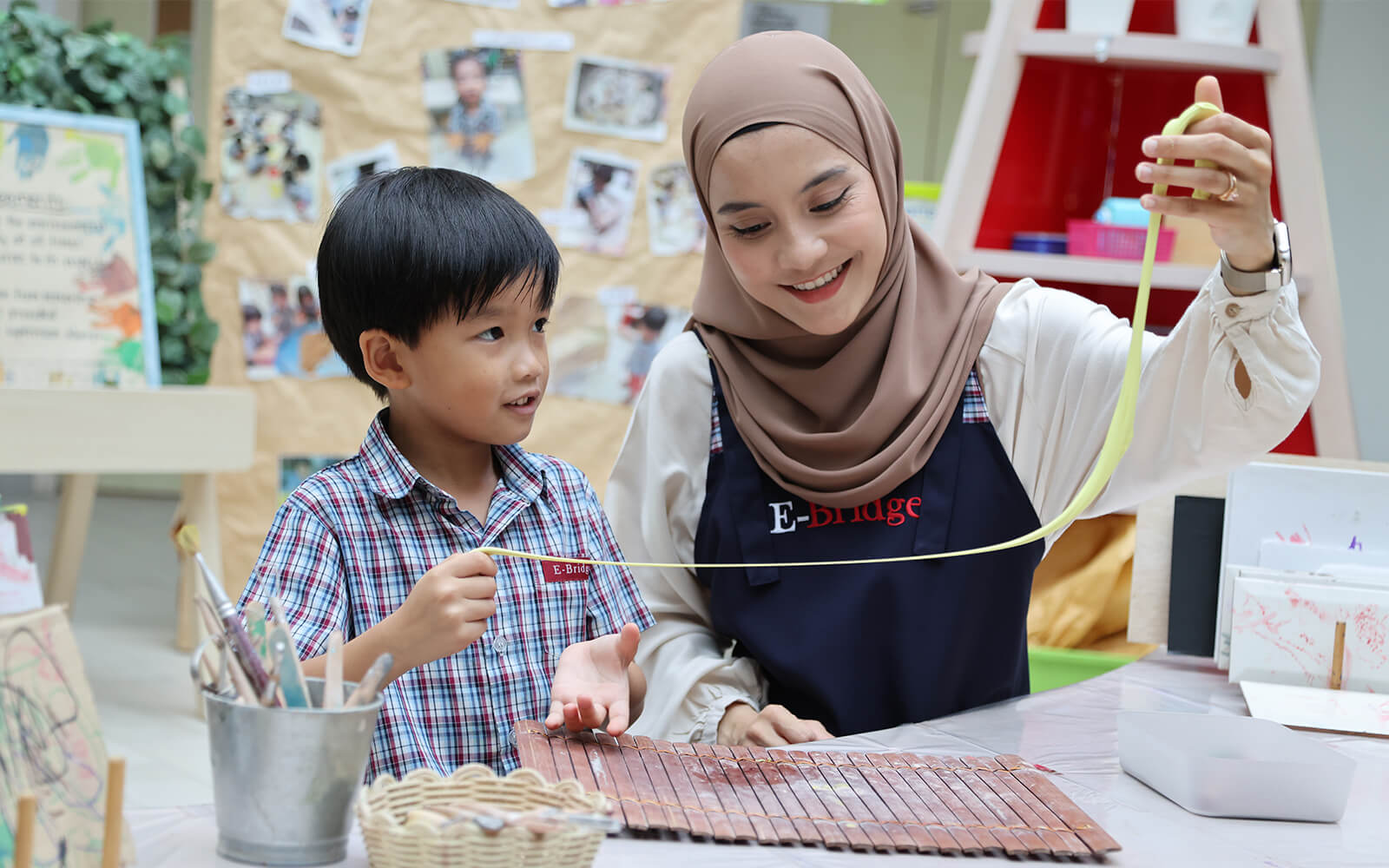 Teacher and child doing an art activity at E-Bridge