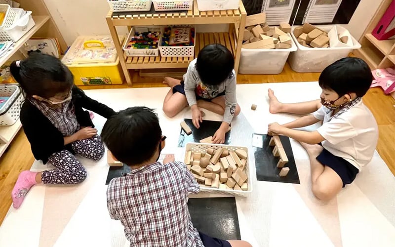 Children playing and learning together with wooden blocks.