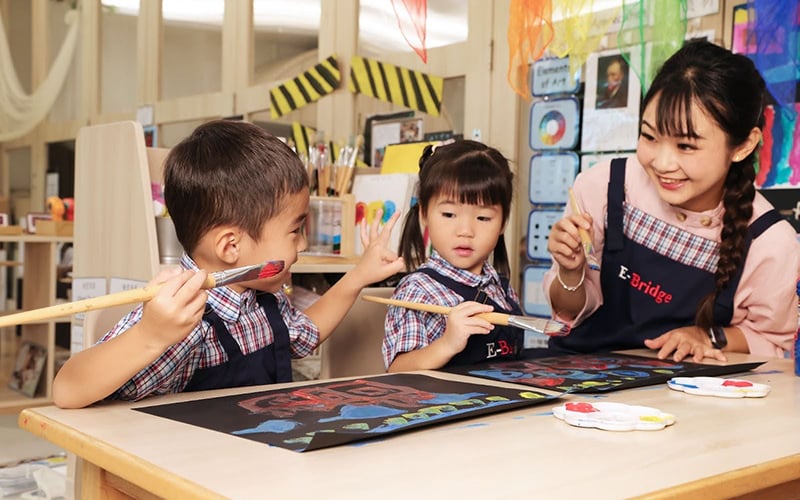 preschool students painting with a teacher