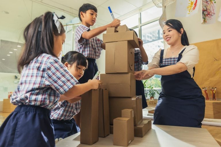 Children and teacher collaborating for a project.