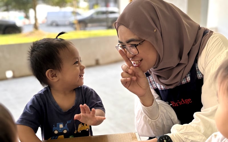 Caregiver engaging in responsive face-to-face interaction with a toddler.